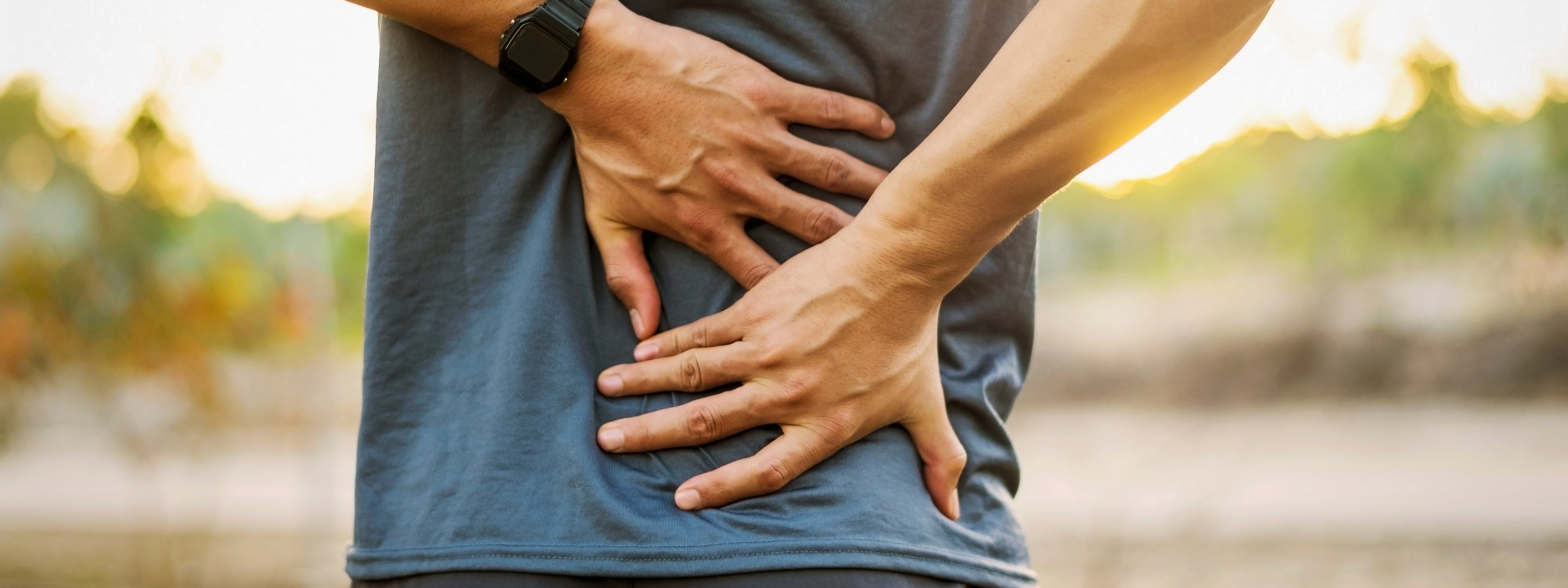 man positions hands on lower back